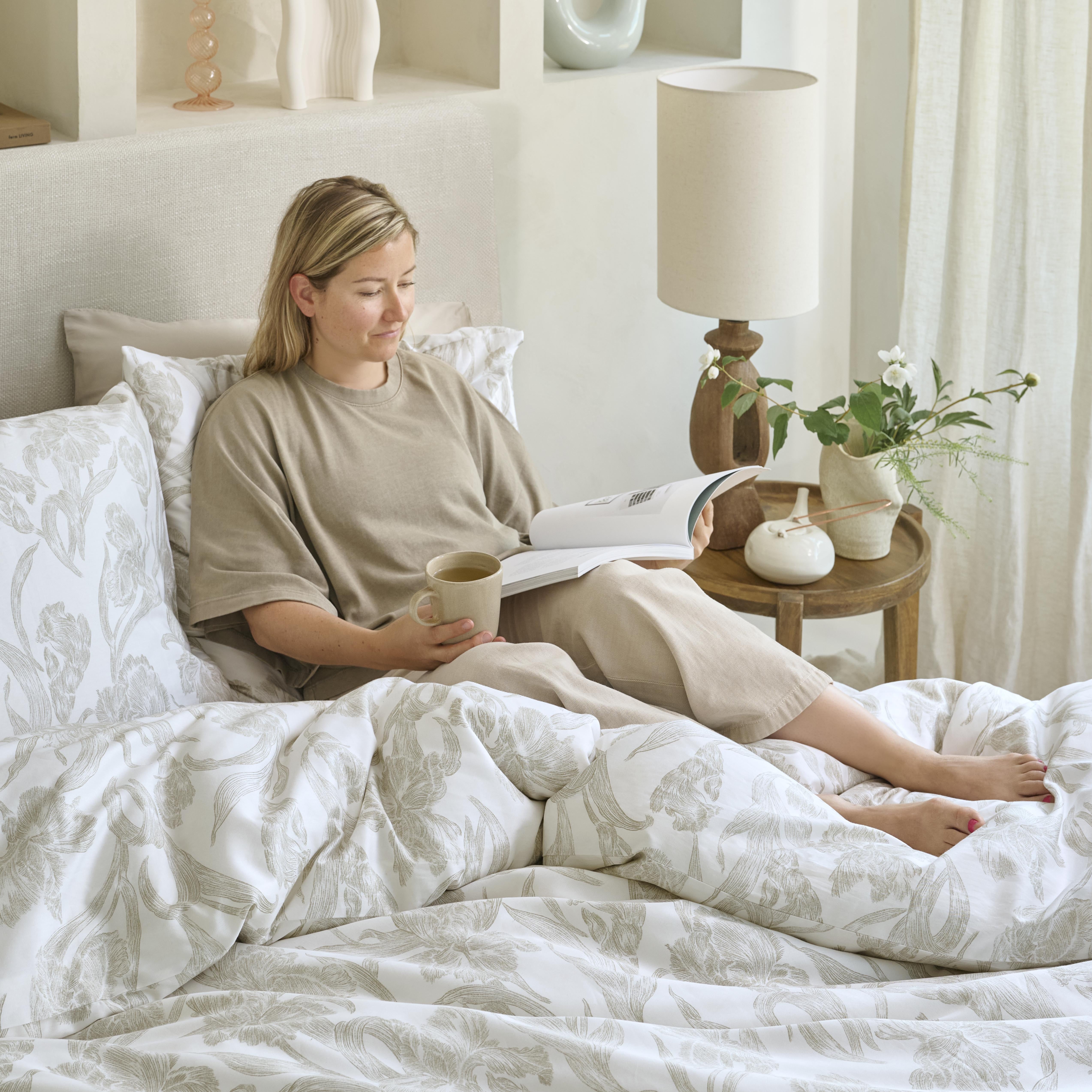 Persoon zit in het bed en leest een boek